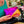 Load image into Gallery viewer, Lady holding Split leather wash bag in hot pink and electric orange.

