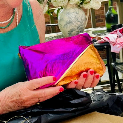 Lady holding Split leather wash bag in hot pink and electric orange.